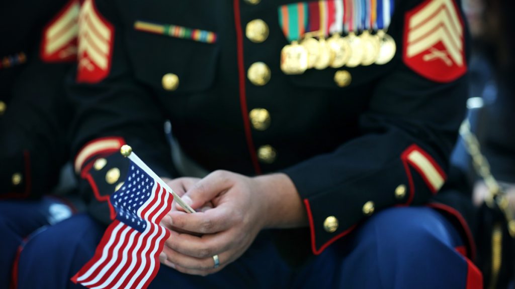 TRIANGLE, VA - NOVEMBER 10:  A U.S. Marine holds a U.S. flag during a naturalization ceremony November 10, 2014 at the National Museum of the Marine Corps in Triangle, Virginia. Service members, military veterans and civilians take part in 40 naturalization ceremonies across the country from November 7 - 14 to honor Veterans Day and become U.S. citizens.  (Photo by Alex Wong/Getty Images)